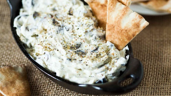 Greek yogurt dip with herbs and pita bread, a creamy Mediterranean appetizer, perfect for snacking or sharing.