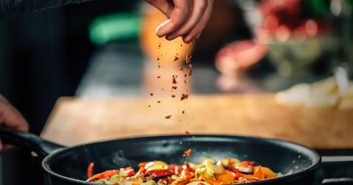 Hot and seasoning spices getting added to a dish