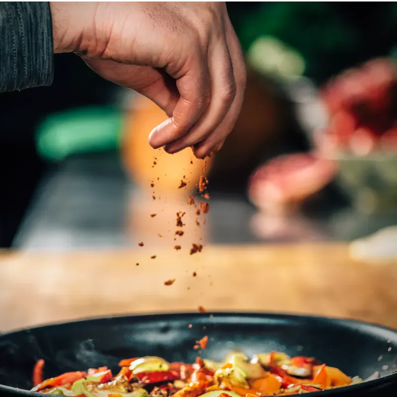 Hot and seasoning spices getting added to a dish