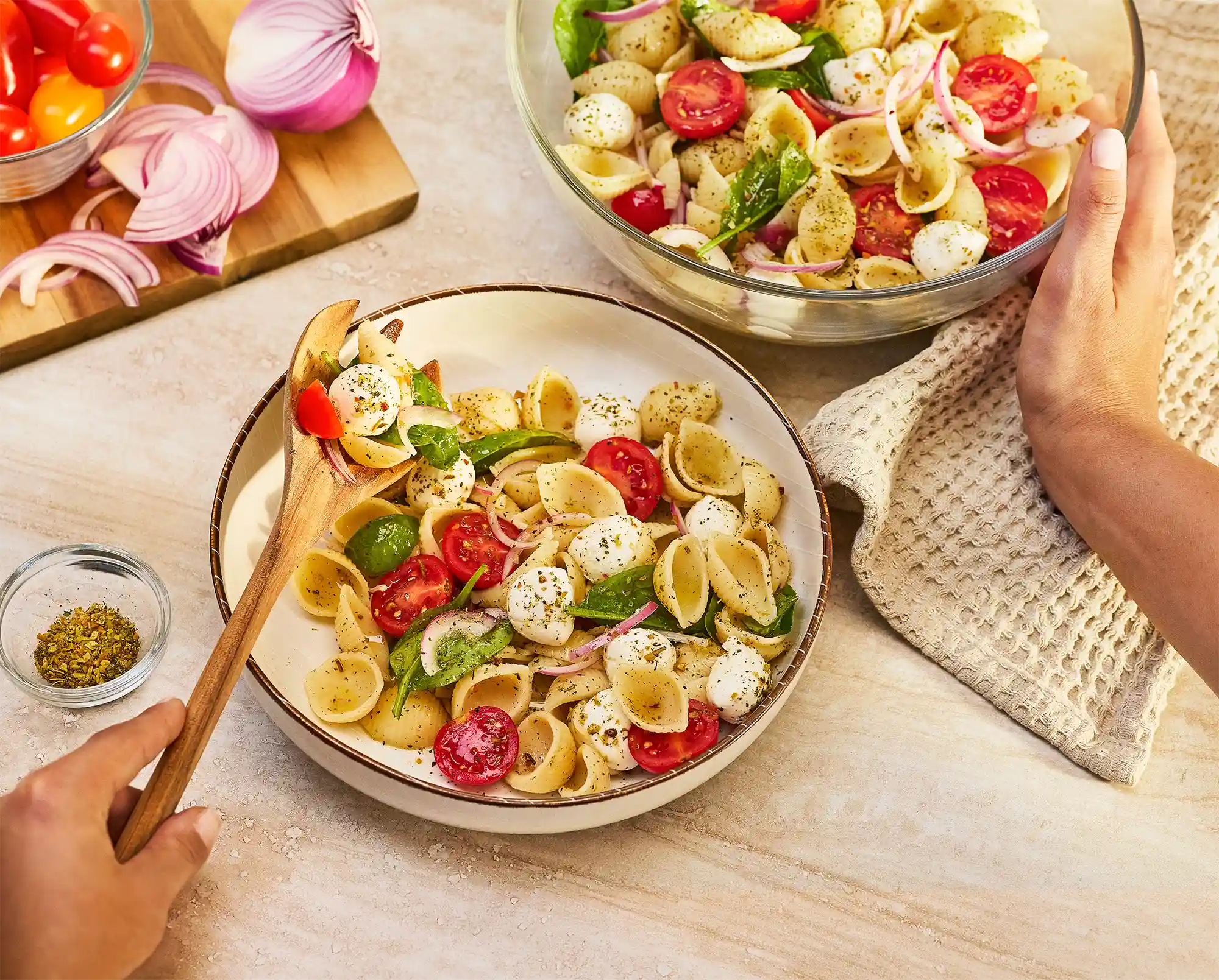 pasta salad caprese on a light wood surface