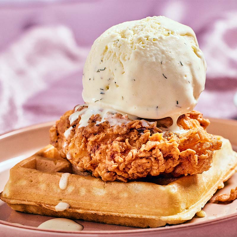 Scoop of buttermilk ranch ice cream on top of chicken and waffles