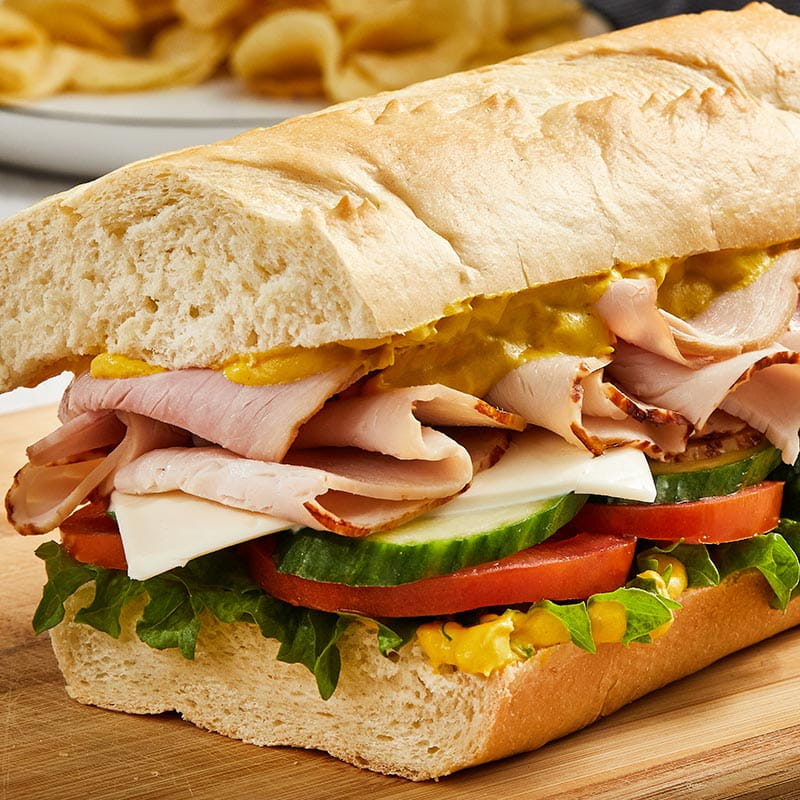 ham and turkey sub with creamy yellow mustard spread